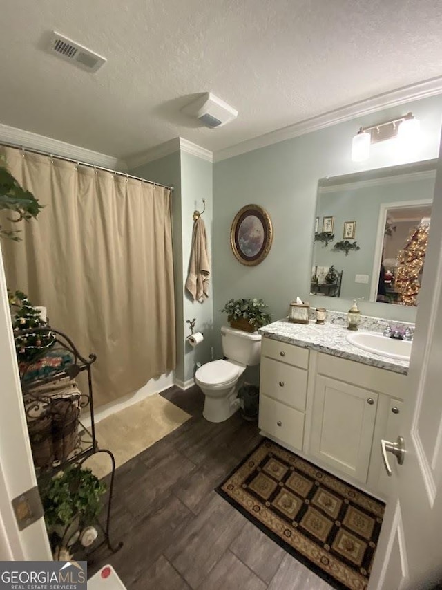 bathroom featuring crown molding, a textured ceiling, toilet, vanity, and hardwood / wood-style flooring