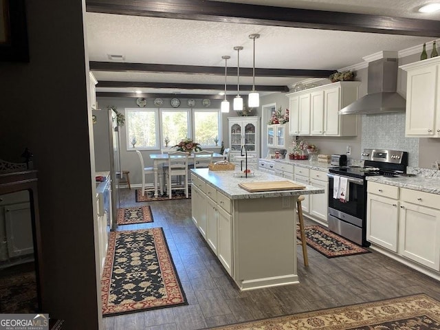 kitchen with light stone countertops, stainless steel electric range oven, a kitchen island with sink, and wall chimney range hood