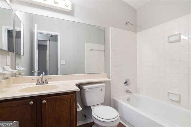 full bathroom featuring vanity, tiled shower / bath combo, and toilet