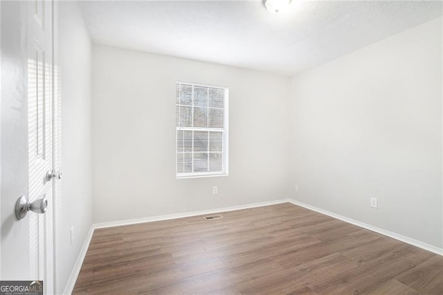 unfurnished room featuring dark wood-type flooring