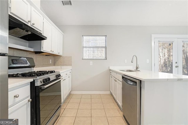 kitchen featuring kitchen peninsula, stainless steel dishwasher, gas range oven, sink, and white cabinets