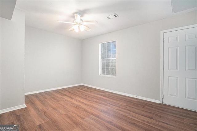 empty room with ceiling fan and dark wood-type flooring