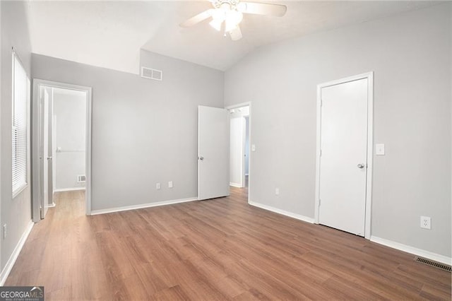 unfurnished bedroom with ceiling fan, lofted ceiling, and hardwood / wood-style flooring