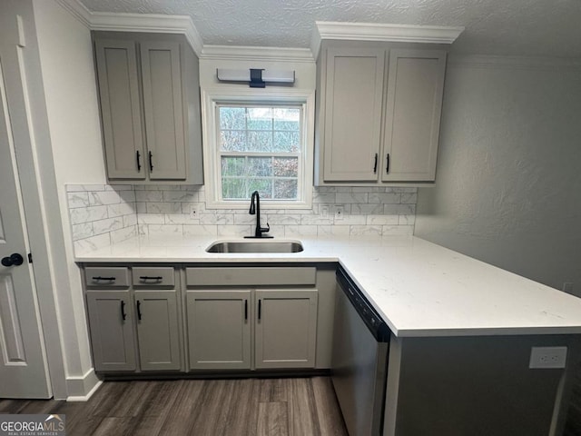 kitchen featuring dishwasher, gray cabinets, tasteful backsplash, and sink