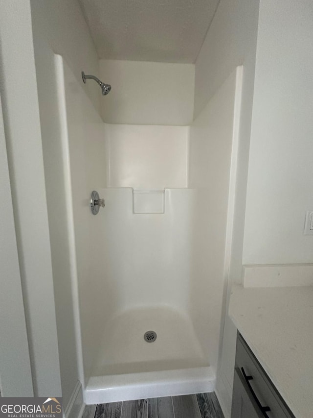 bathroom with vanity, wood-type flooring, and walk in shower