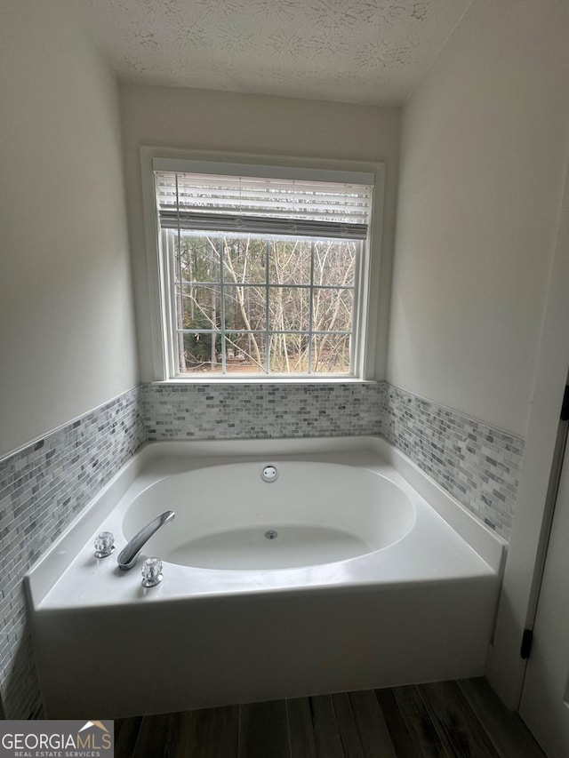 bathroom featuring a textured ceiling and a bathtub