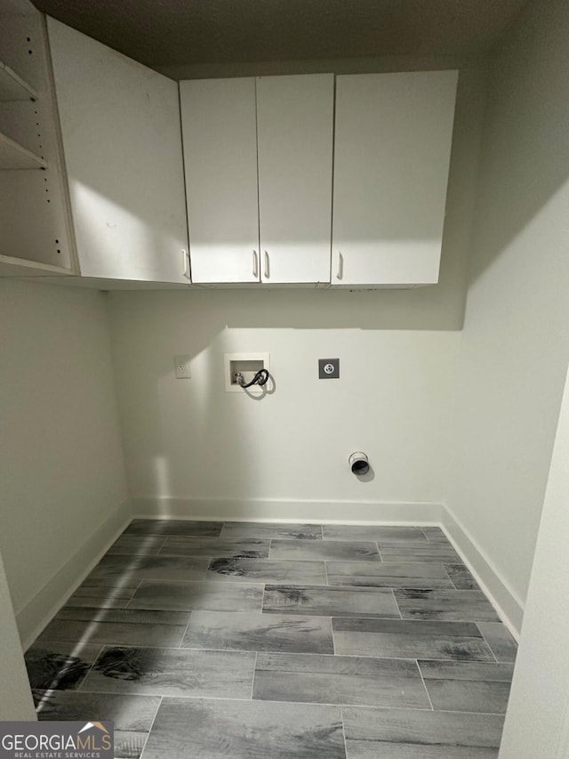 washroom with hookup for an electric dryer, cabinets, and washer hookup