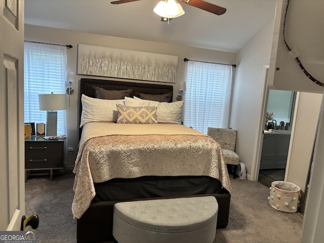 carpeted bedroom featuring ceiling fan, lofted ceiling, sink, and multiple windows