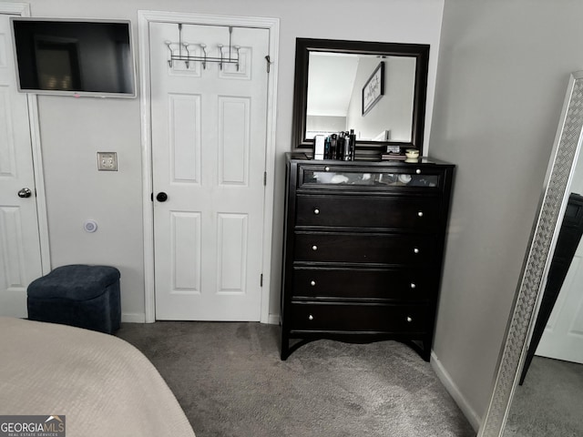 carpeted bedroom featuring a closet and baseboards