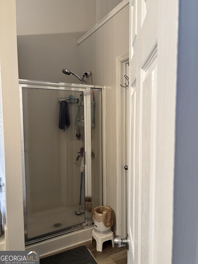 bathroom with a stall shower and wood finished floors