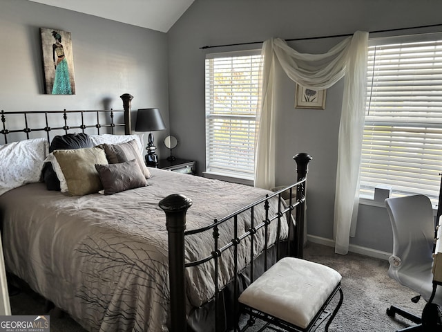 carpeted bedroom featuring lofted ceiling and baseboards