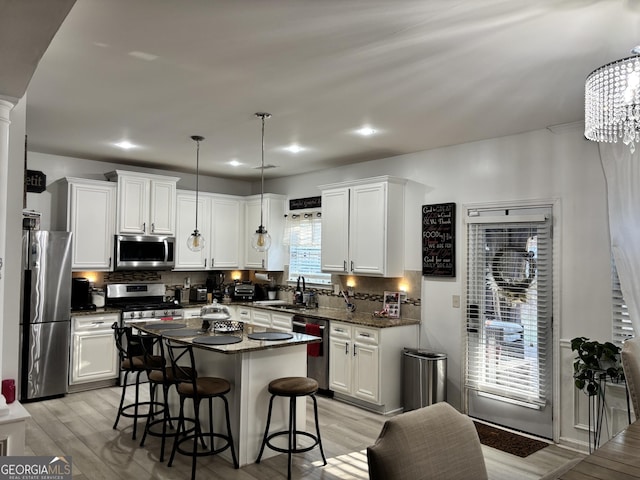 kitchen featuring light wood finished floors, appliances with stainless steel finishes, and white cabinetry