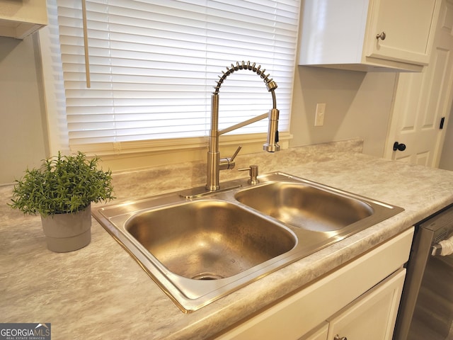 kitchen with white cabinets, dishwashing machine, and sink