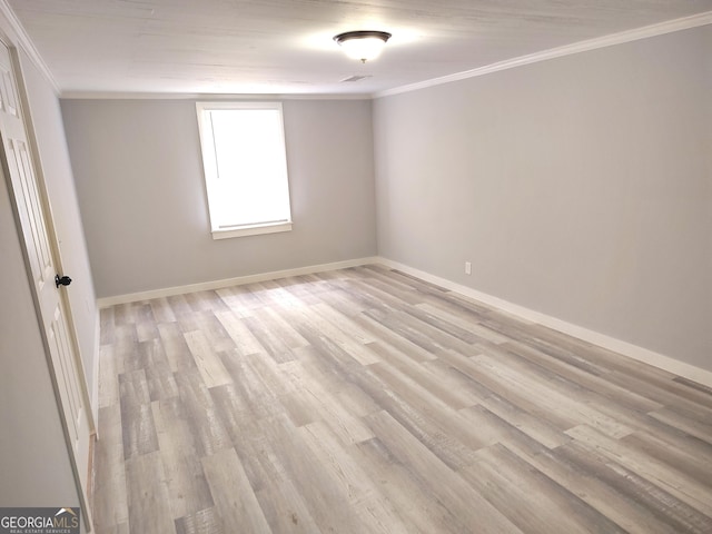 spare room with light wood-type flooring and crown molding