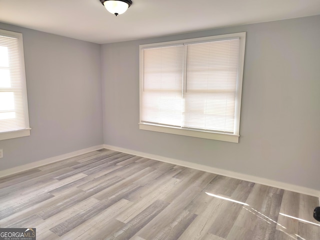 unfurnished room featuring light hardwood / wood-style floors and a healthy amount of sunlight