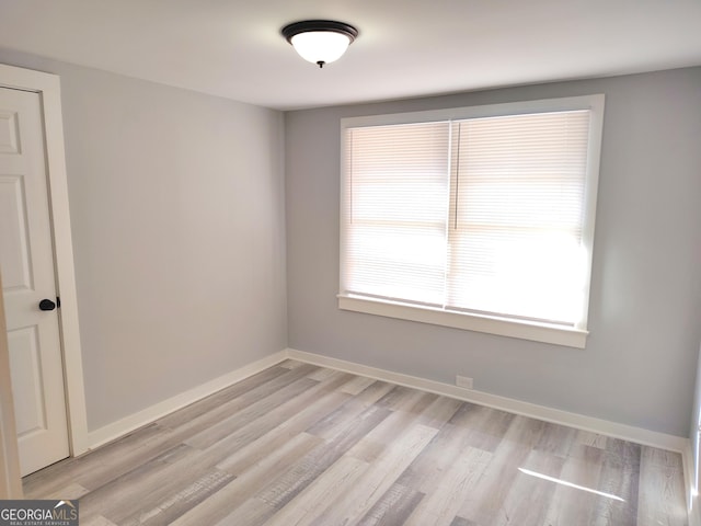 spare room with light wood-type flooring and a wealth of natural light