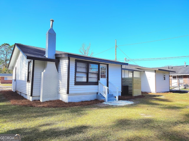 rear view of property with a yard