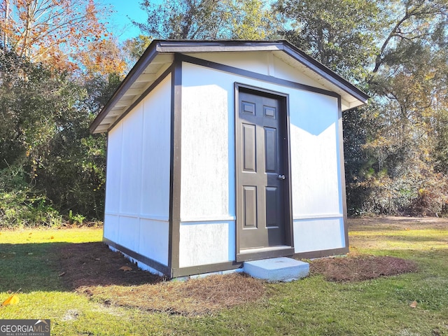 view of outdoor structure featuring a lawn