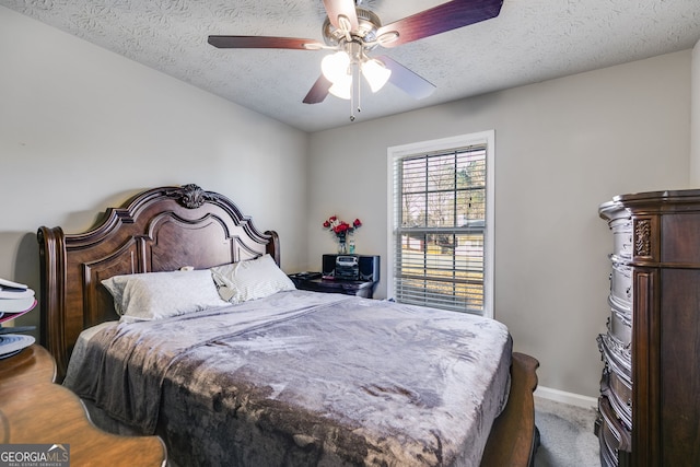 carpeted bedroom featuring a textured ceiling and ceiling fan