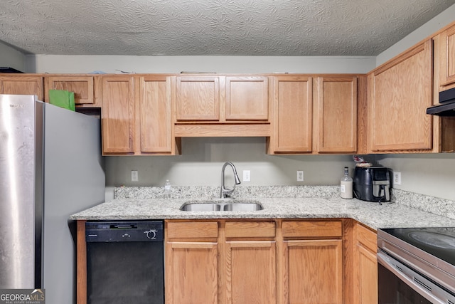 kitchen featuring light stone countertops, sink, stainless steel appliances, a textured ceiling, and light brown cabinetry