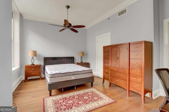 bedroom with light hardwood / wood-style flooring, ceiling fan, and ornamental molding