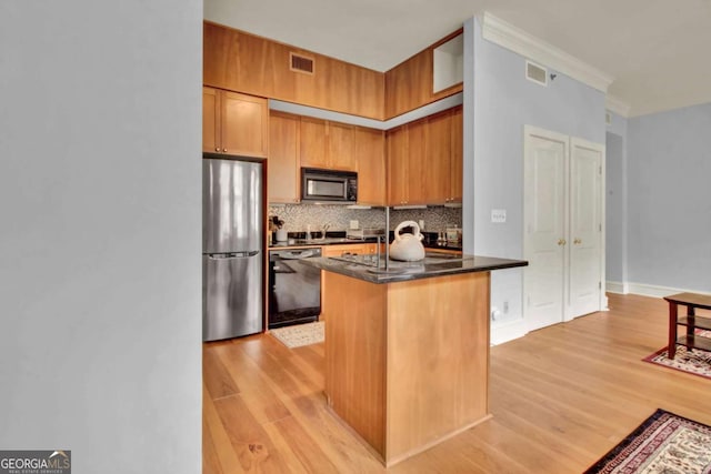 kitchen featuring decorative backsplash, ornamental molding, black appliances, and light hardwood / wood-style floors