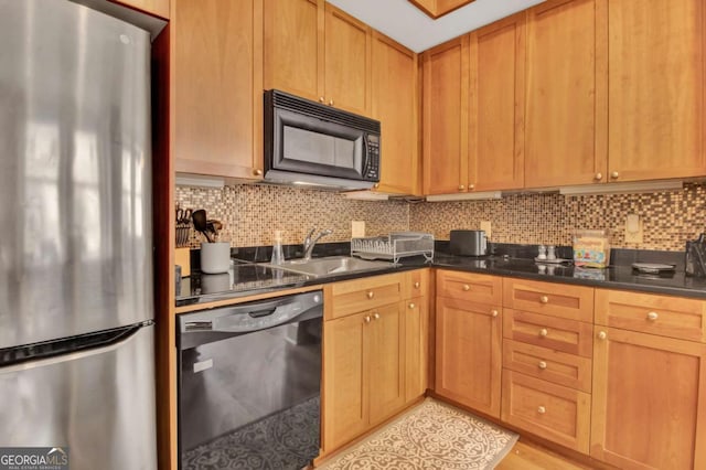 kitchen featuring sink, backsplash, and black appliances