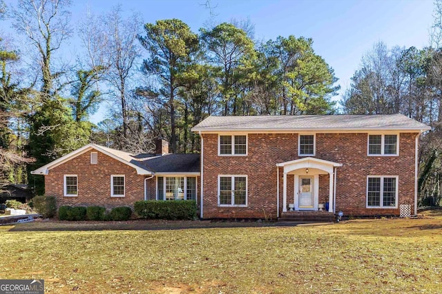 colonial inspired home featuring a front lawn