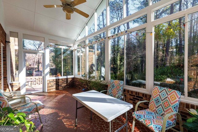 sunroom with vaulted ceiling, a wealth of natural light, and ceiling fan