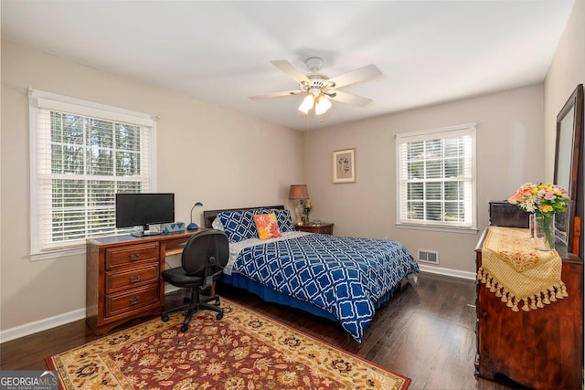 bedroom featuring dark hardwood / wood-style flooring, multiple windows, and ceiling fan