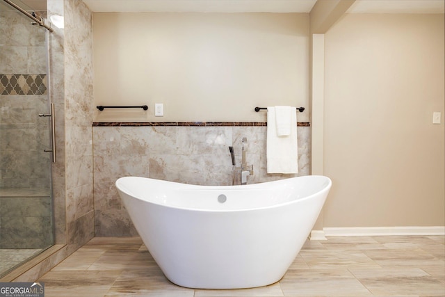 bathroom featuring tile patterned floors, plus walk in shower, and tile walls