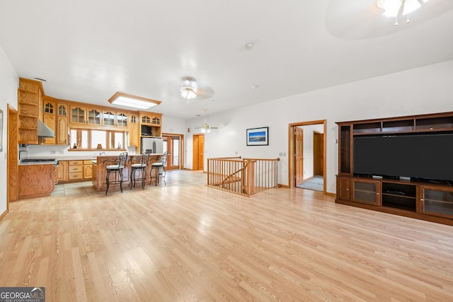 living room with ceiling fan and light wood-type flooring