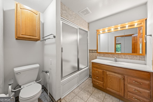 full bathroom with tile patterned floors, vanity, toilet, and shower / bath combination with glass door