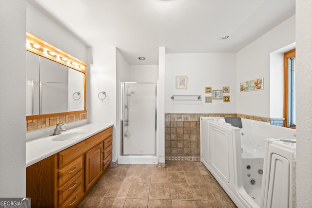 bathroom with separate shower and tub, tile patterned flooring, vanity, and tile walls