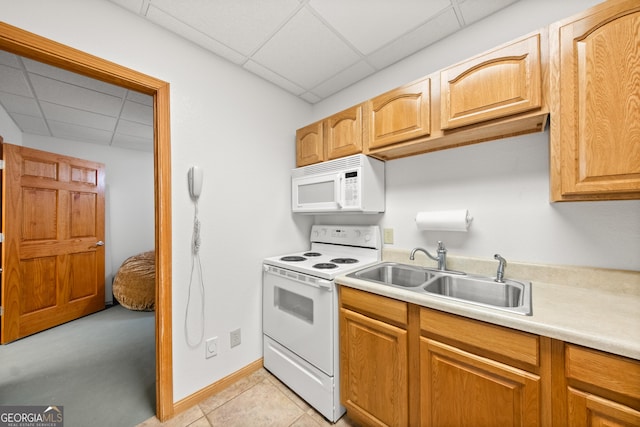 kitchen featuring light tile patterned floors, white appliances, a paneled ceiling, and sink