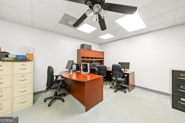 home office with a paneled ceiling and ceiling fan