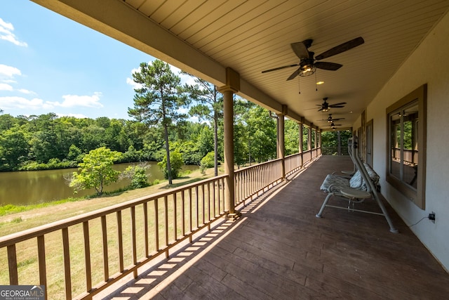 deck with ceiling fan and a water view