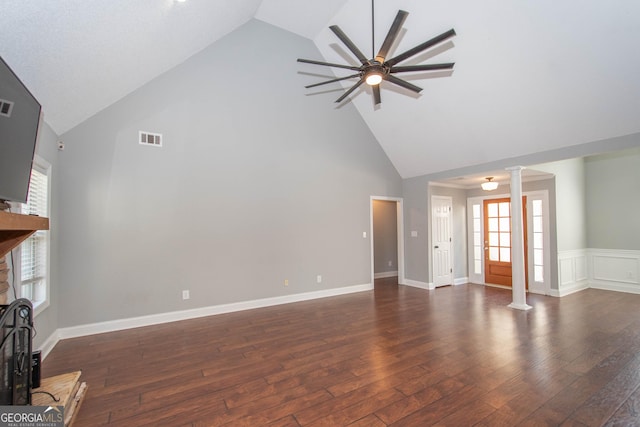 unfurnished living room featuring high vaulted ceiling, dark hardwood / wood-style floors, ceiling fan, a fireplace, and decorative columns