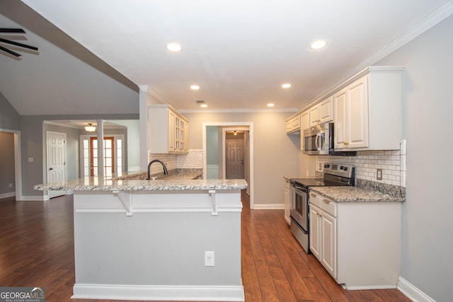 kitchen featuring a kitchen breakfast bar, kitchen peninsula, stainless steel appliances, light stone countertops, and dark wood-type flooring