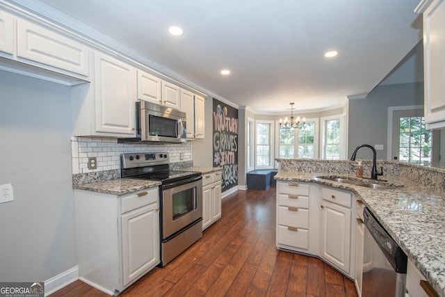 kitchen with sink, white cabinetry, decorative light fixtures, appliances with stainless steel finishes, and dark hardwood / wood-style flooring