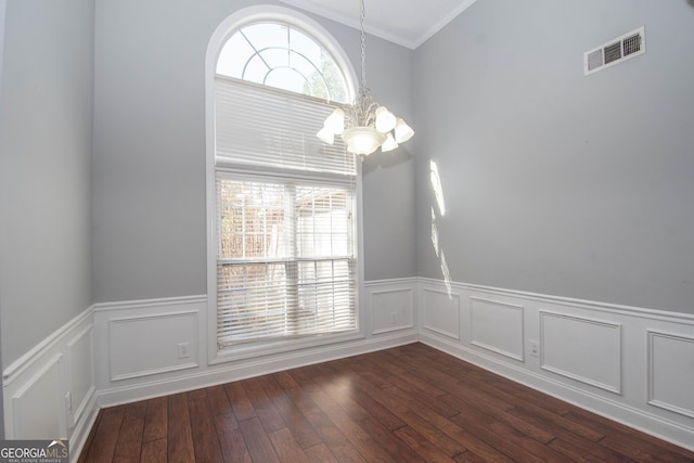 unfurnished room featuring ornamental molding, dark hardwood / wood-style flooring, and a chandelier