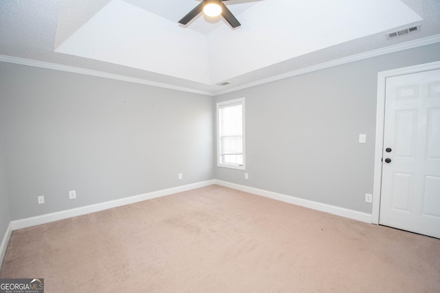 carpeted empty room featuring crown molding, ceiling fan, and a raised ceiling