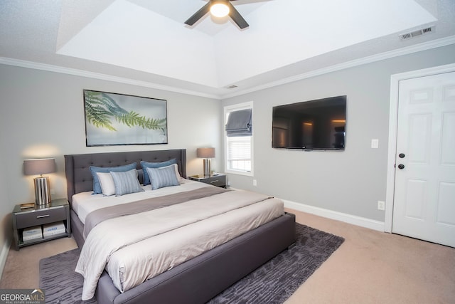 carpeted bedroom featuring ceiling fan, ornamental molding, and a tray ceiling