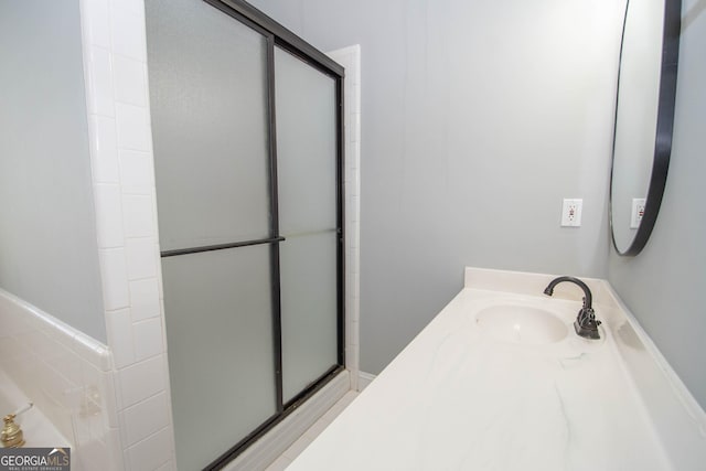 bathroom with vanity and a shower with shower door