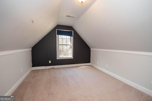 additional living space featuring lofted ceiling and light carpet