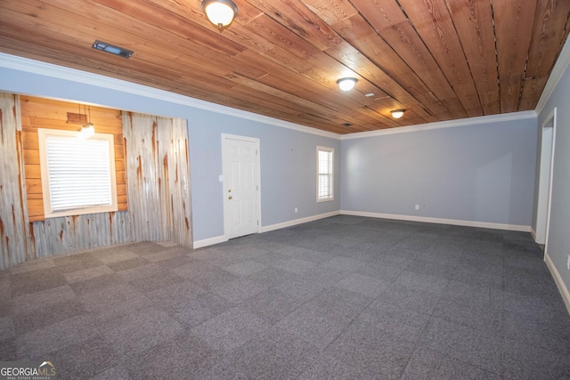 empty room featuring crown molding, carpet flooring, wooden walls, and wooden ceiling