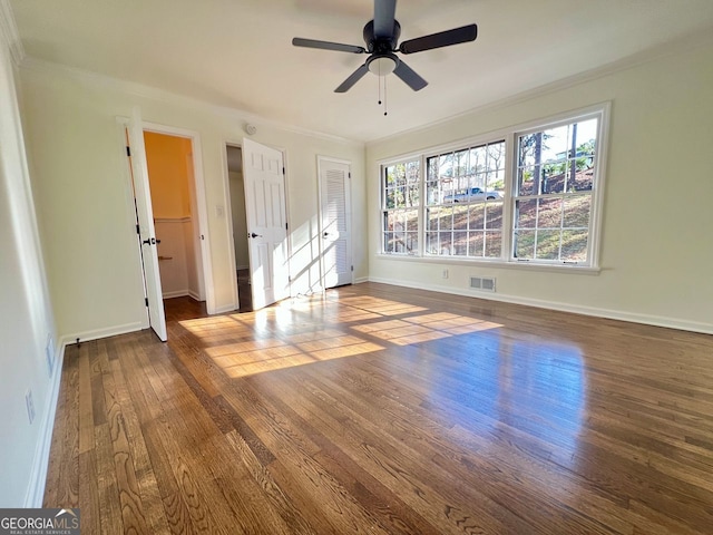 unfurnished bedroom with dark hardwood / wood-style floors, ceiling fan, and crown molding