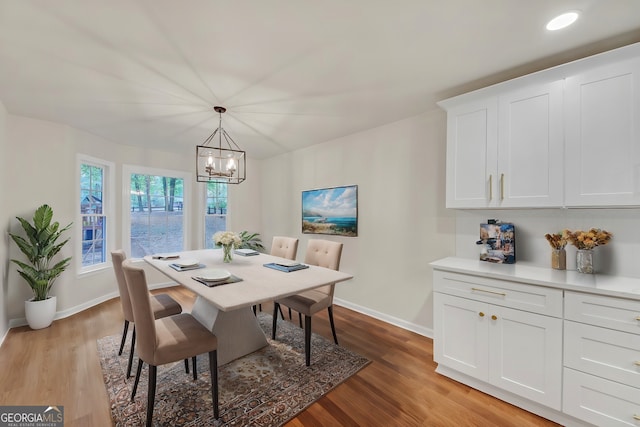 dining room with light hardwood / wood-style flooring and a chandelier