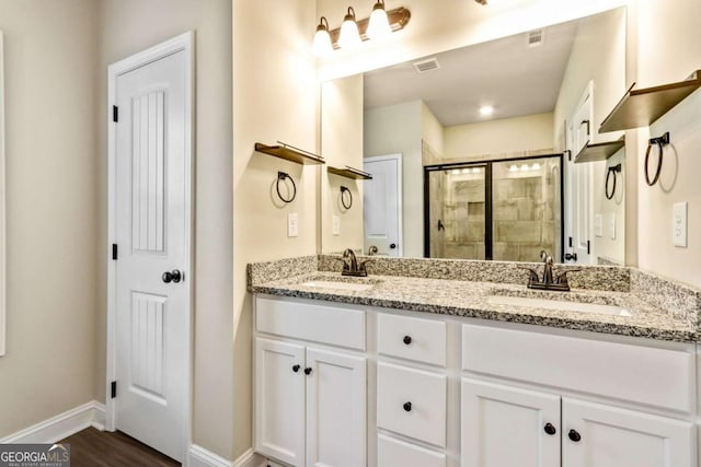 bathroom with a shower with door, vanity, and wood-type flooring