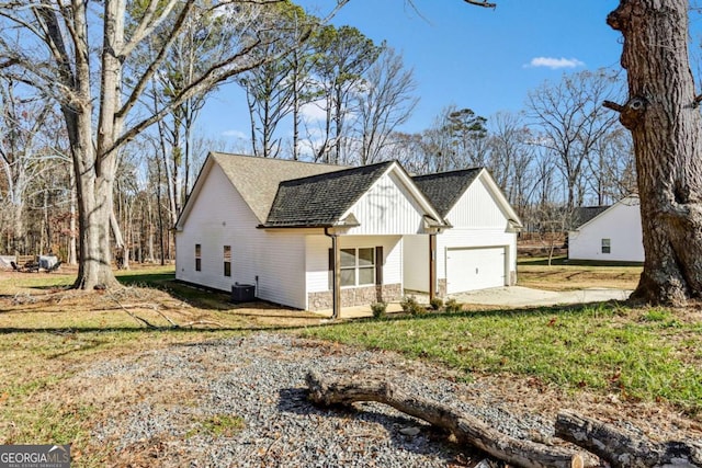 modern farmhouse with cooling unit, a front lawn, and a garage